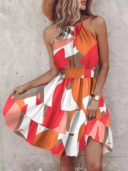 Woman wearing a colorful dress with a pattern against a plain background