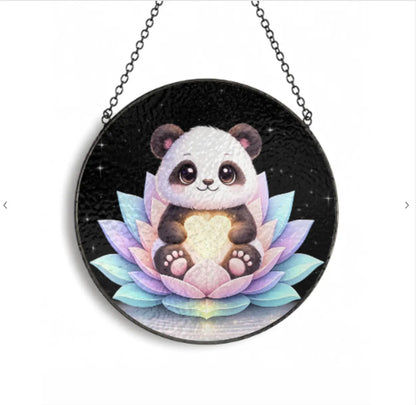 Circular pendant with a panda and lotus design on a black background